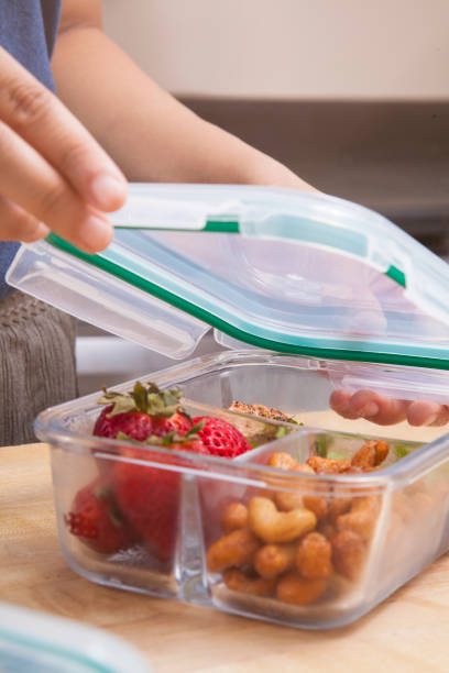 istock Meal prepping by sorting berries, notes, and fresh food into clear glass containers 1366178479