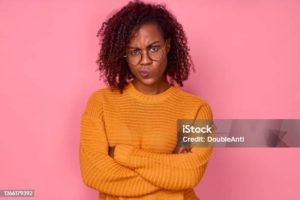 Sad Young African American Woman Displeased Looking At Camera With Crossed Arms Over Pink Background Stock Photo - Download Image Now