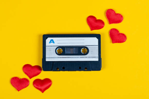 Old Audio Tape Cassette Old Audio Cassette with a Red Hearts on the Yellow Paper Background closeup mix tape heart stock pictures, royalty-free photos & images