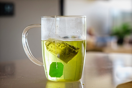 Cup of green tea brewing