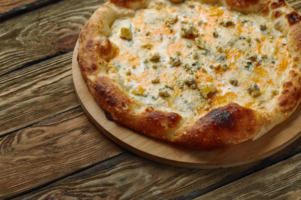 istock Italian Pizza Quattro formaggi on wooden table 1366183778