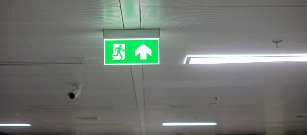istock Fire Emergency exit sign on the wall inside building at subway train station. Safety concept 1366184652