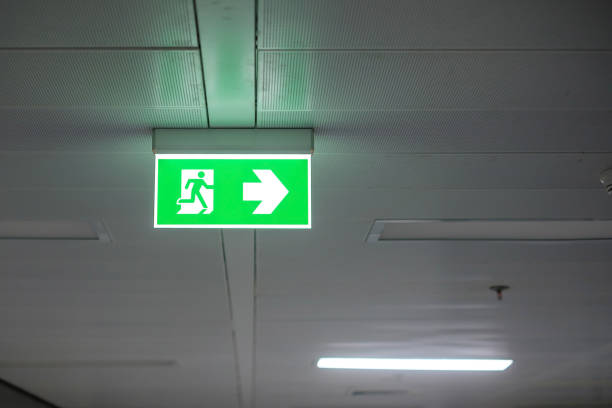 istock Fire Emergency exit sign on the wall inside building at subway train station. Safety concept 1366184665