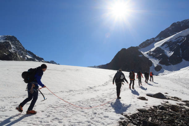 オーストリアのチロルアルプスの青空を持つ氷河タシャッハフェルナーと山の雪のパノラマのクランポンとロープチーム登山 - ötztal alps ストックフォトと画像