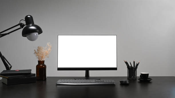 istock Computer, coffee cup, pencil holder and lamp on black table at stylish workplace. 1366187509