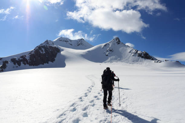 オーストリアのチロルアルプスで青空を持つワイルドスピッツェと山の雪のパノラマに向かって氷河タシャッハフェルナーのクランポンと登山ロープチーム - ötztal alps ストックフォトと画像