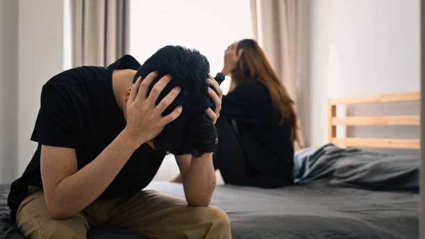 young asian couple with relationship problem sitting on bed with their backs turned to each other. family problems concept. - stereotypical housewife depression sadness women imagens e fotografias de stock