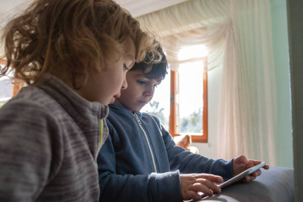 istock Inside the house, two brothers stare at the tablet with full attention 1366188090