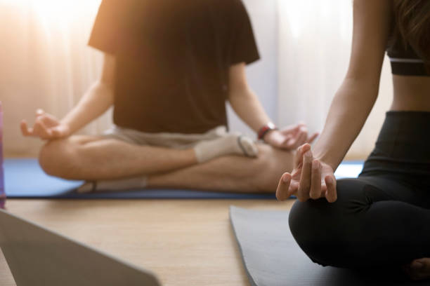 istock Young healthy couple practicing yoga in a bright classroom. 1366188149