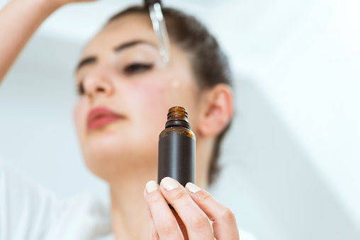 Woman applying face serum