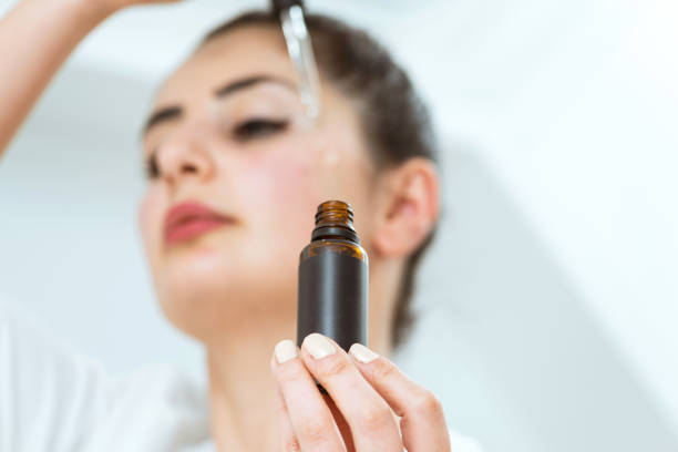 Woman applying face serum stock photo