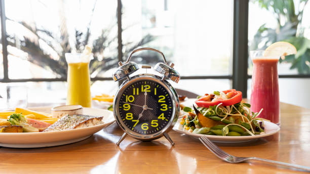 istock Selective focus of Alarm clock with Intermittent fasting method 16/8 eating time.Healthy lifestyle concept 1366195170