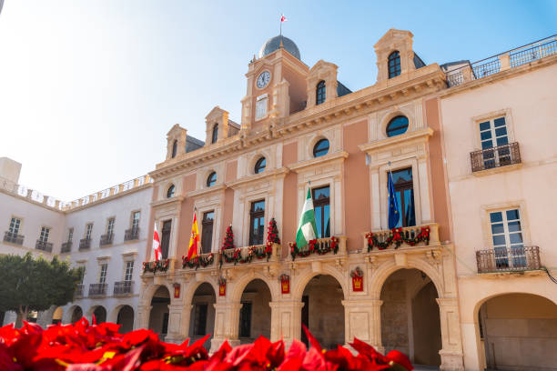 flores vermelhas na praça da prefeitura da cidade de almeria, andaluzia. espanha. costa do sol no mar mediterrâneo - spain tower town square andalusia - fotografias e filmes do acervo