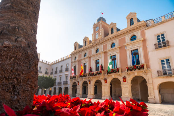 flores vermelhas na praça da prefeitura da cidade de almeria, andaluzia. espanha. costa do sol no mar mediterrâneo - spain tower town square andalusia - fotografias e filmes do acervo