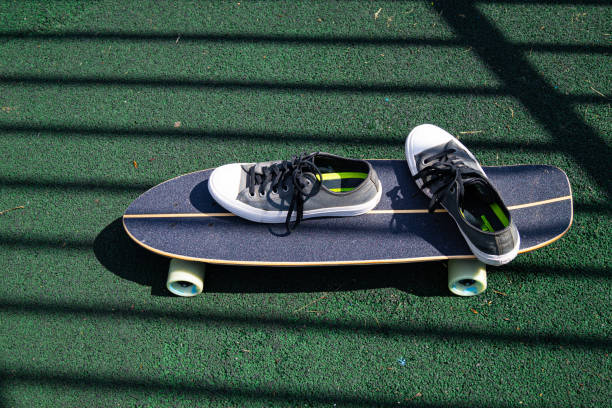 istock gray men's sneakers on a gray skateboard 1366206259
