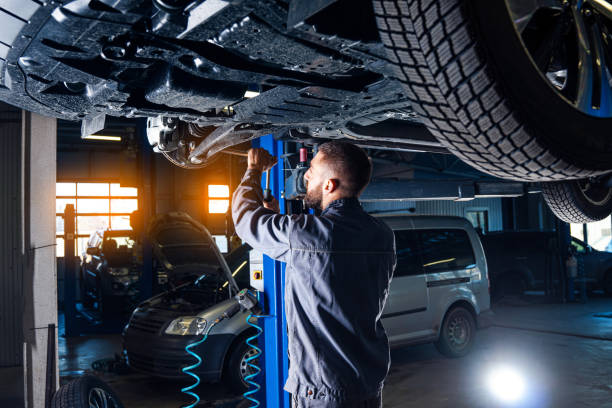 Auto service station background. Mechanic repairs car chassis using a car lift. stock photo