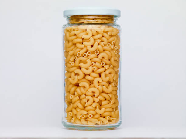Pasta in glass jar on a white background A jar of pasta Processed and Refined Carbohydrates: stock pictures, royalty-free photos & images