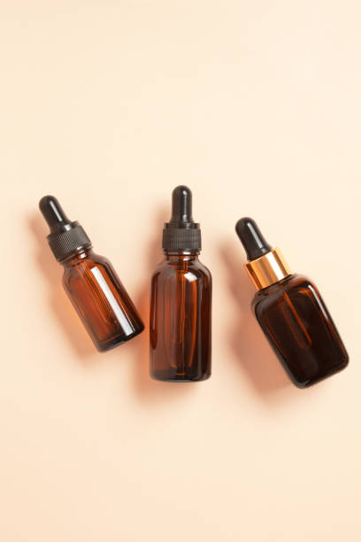 istock Amber glass dropper bottles different sizes on beige background. Cosmetic container mock-ups. Background for branding. Natural skincare beauty product concept 1366209862