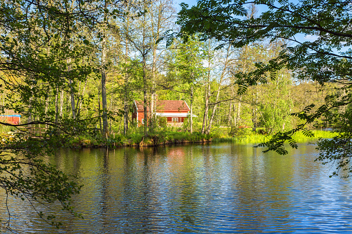Mullsjlö, Sweden - June 04, 2017: River in the forest with a red cottage