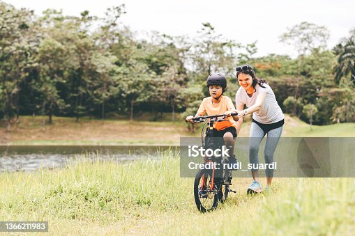 istock mother teaching son to ride a bicycle 1366211983