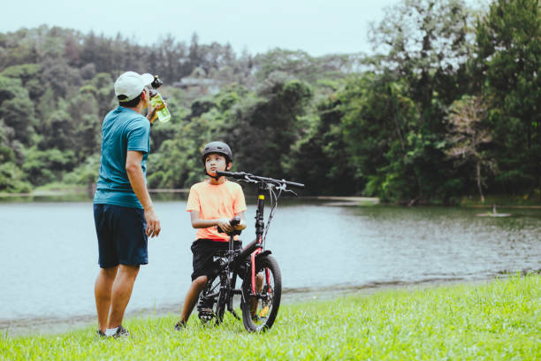 father and son taking rest when riding on the forest