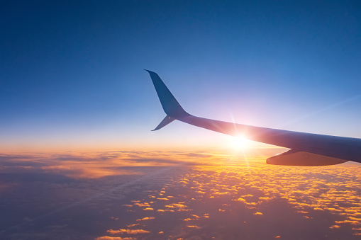 Sunset sky from an airplane wing view of the horizon and sun lights.