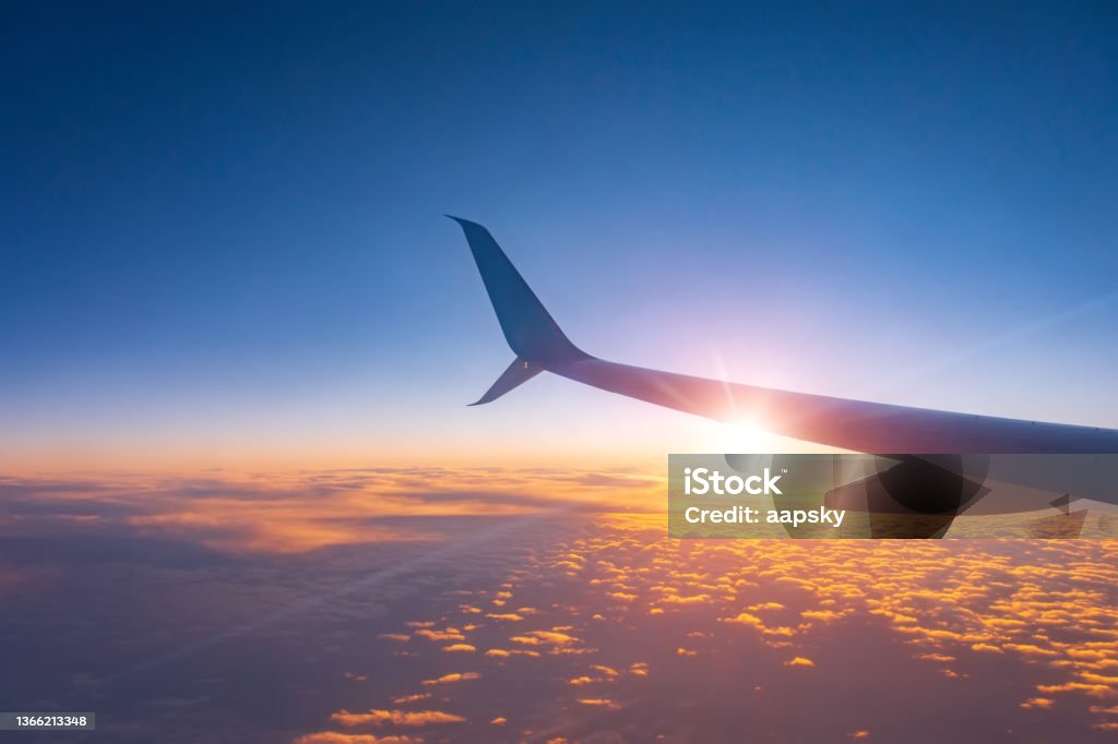 Sunset sky from an airplane wing view of the horizon and sun lights. Sunset sky from an airplane wing view of the horizon and sun lights Airplane Stock Photo