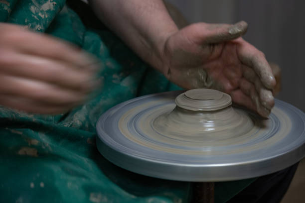 istock Potter at work. Hands of potter do a clay pot 1366215073