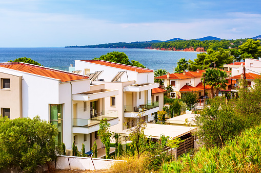 Nikiti, Sithonia, Chalkidiki Peninsula, Greece panorama with houses, blue sea and red rocks mountains