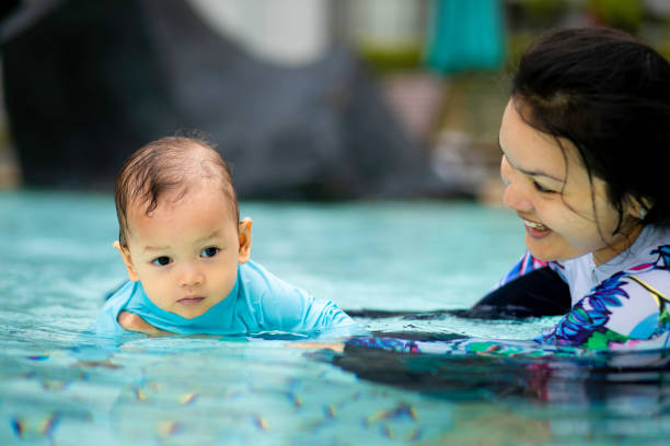 istock asian young mother teaching her baby swimming 1366220028