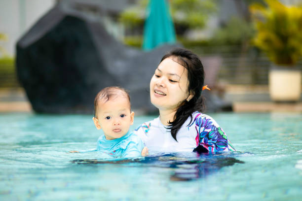 istock asian young mother teaching her baby swimming 1366220069