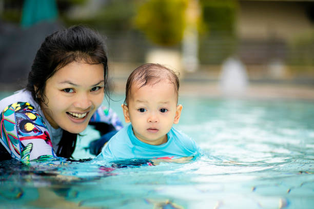 istock asian young mother teaching her baby swimming 1366220076