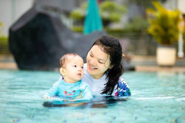 istock asian young mother teaching her baby swimming 1366220079