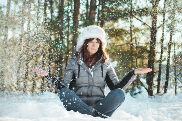istock Young woman meditates in winter park. 1366220253