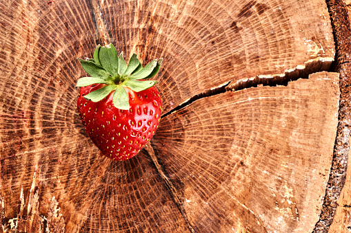 Ripe fresh red strawberry isolated on wooden background