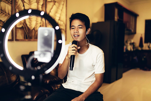 young man singing with mic at home