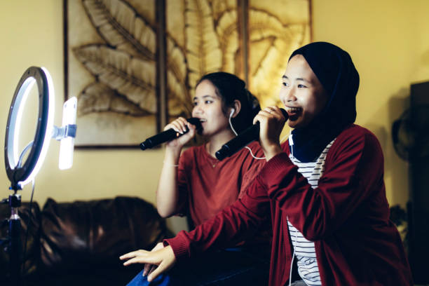 istock Two women singing karaoke. 1366221976