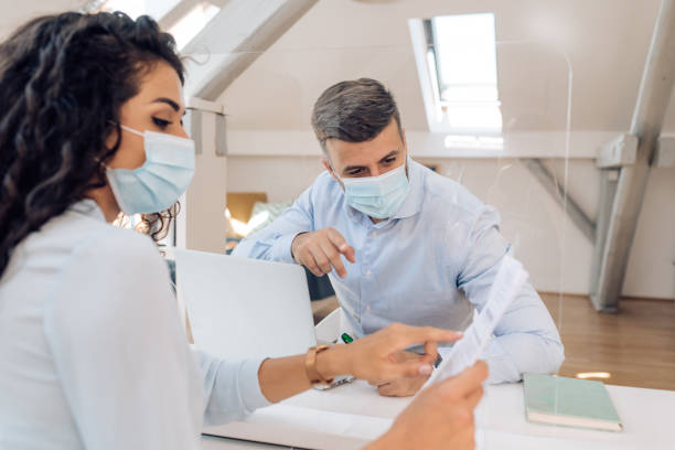 istock Manager and his employee cooperating through the protective glass 1366223149