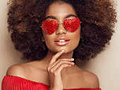 istock Beautiful portrait of an African girl in sunglasses in the shape of hearts 1366224227