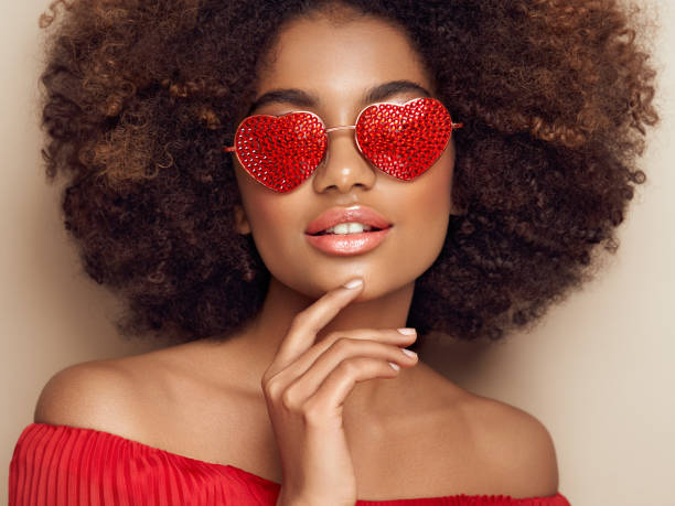 Beautiful portrait of an African girl in sunglasses in the shape of hearts stock photo