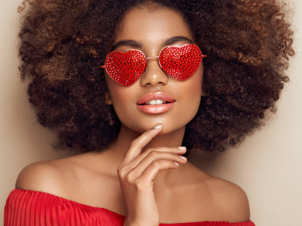 beautiful portrait of an african girl in sunglasses in the shape of hearts - fashion model pink beauty fashion imagens e fotografias de stock