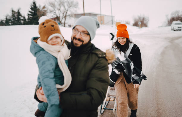 istock Mom, dad and baby are sledding 1366226064