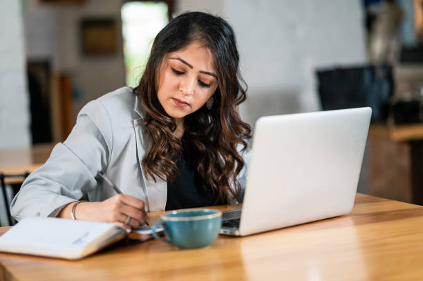 istock Young Female Studying On Laptop In Coffee Bar. 1366226565