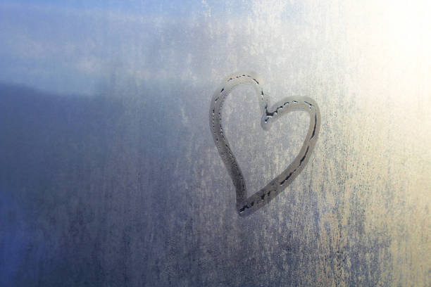 Heart drawn on a glass by hand. Close-up. Background. Texture. stock photo