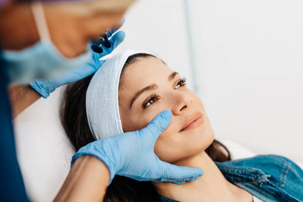 Facial aesthetics surgery treatment Attractive young woman is getting a rejuvenating facial injections at beauty clinic. The expert beautician is filling female wrinkles by botulinum. aesthetician photos stock pictures, royalty-free photos & images