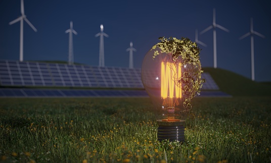 Glowing lightbulb in front of the solar panels and wind turbines, symbolizing sustainable energy and finance concepts. (3d render)