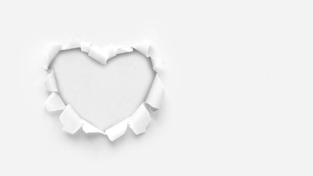 hole in the shape of a heart A paper hole with torn edges on a white background. Through paper. A ragged hole in the shape of a heart. Valentine's day. A symbol of love, romantic relationships. International Women's Day. falling in love photos stock pictures, royalty-free photos & images