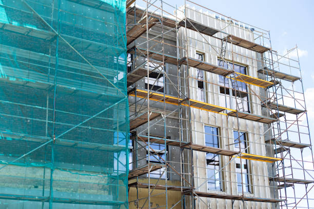 istock Building under construction against blue sky. New high-rise building under construction with brick work and wooden scaffolding. Concrete building under construction. 1366231369
