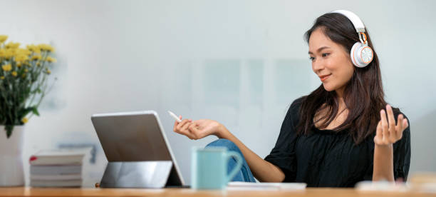 istock A young female college student with headphone sitting at the table, using portable tablet when studying. Online learning. 1366231382