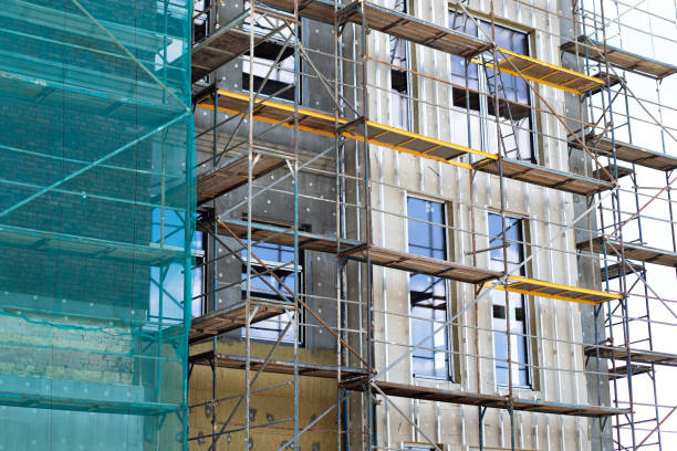 istock Building under construction against blue sky. New high-rise building under construction with brick work and wooden scaffolding. Concrete building under construction. 1366231410